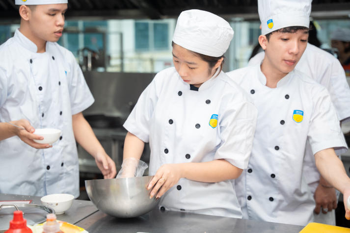 Restaurant and Catering Management students engaged in a signature Bánh mì workshop guided by a culinary expert 78